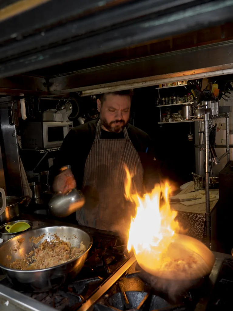 Retrato de Andrés Ocaña cocinando frente a una llamarada
