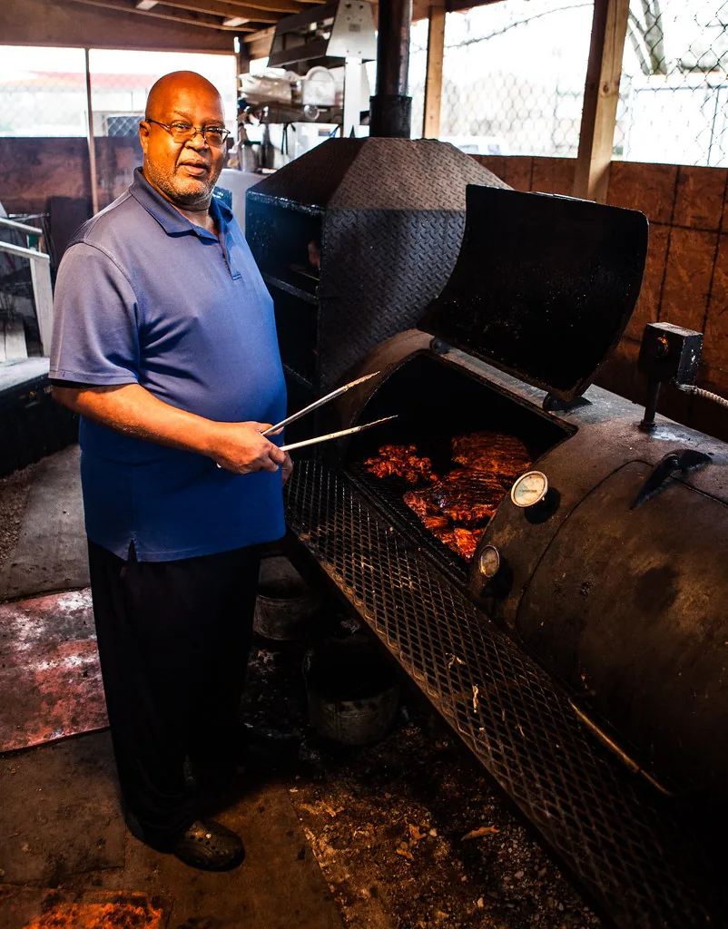 Óscar Peña atendiendo el ahumador de costillas
